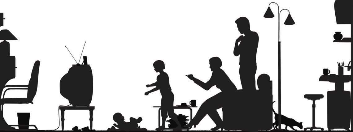 Silhouette of a family with a baby watching television